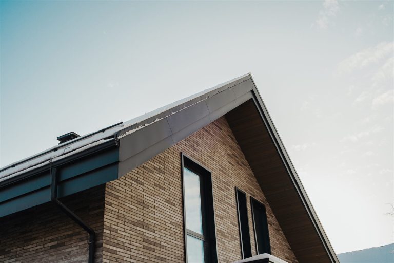 Steep gable roof on a brick house with a dark gutter along the eave